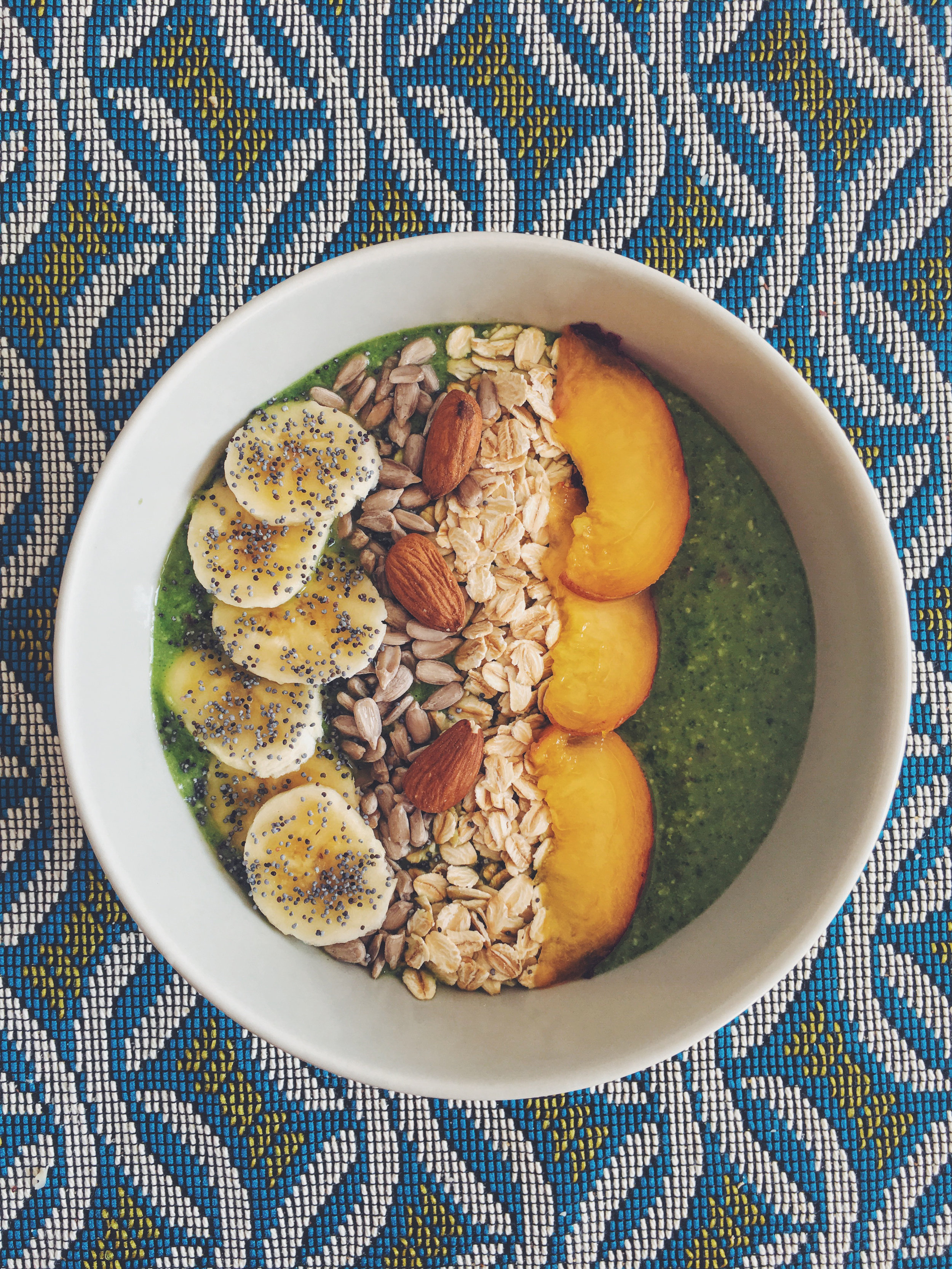 green smoothie bowl with coconut, seeds and fresh fruits