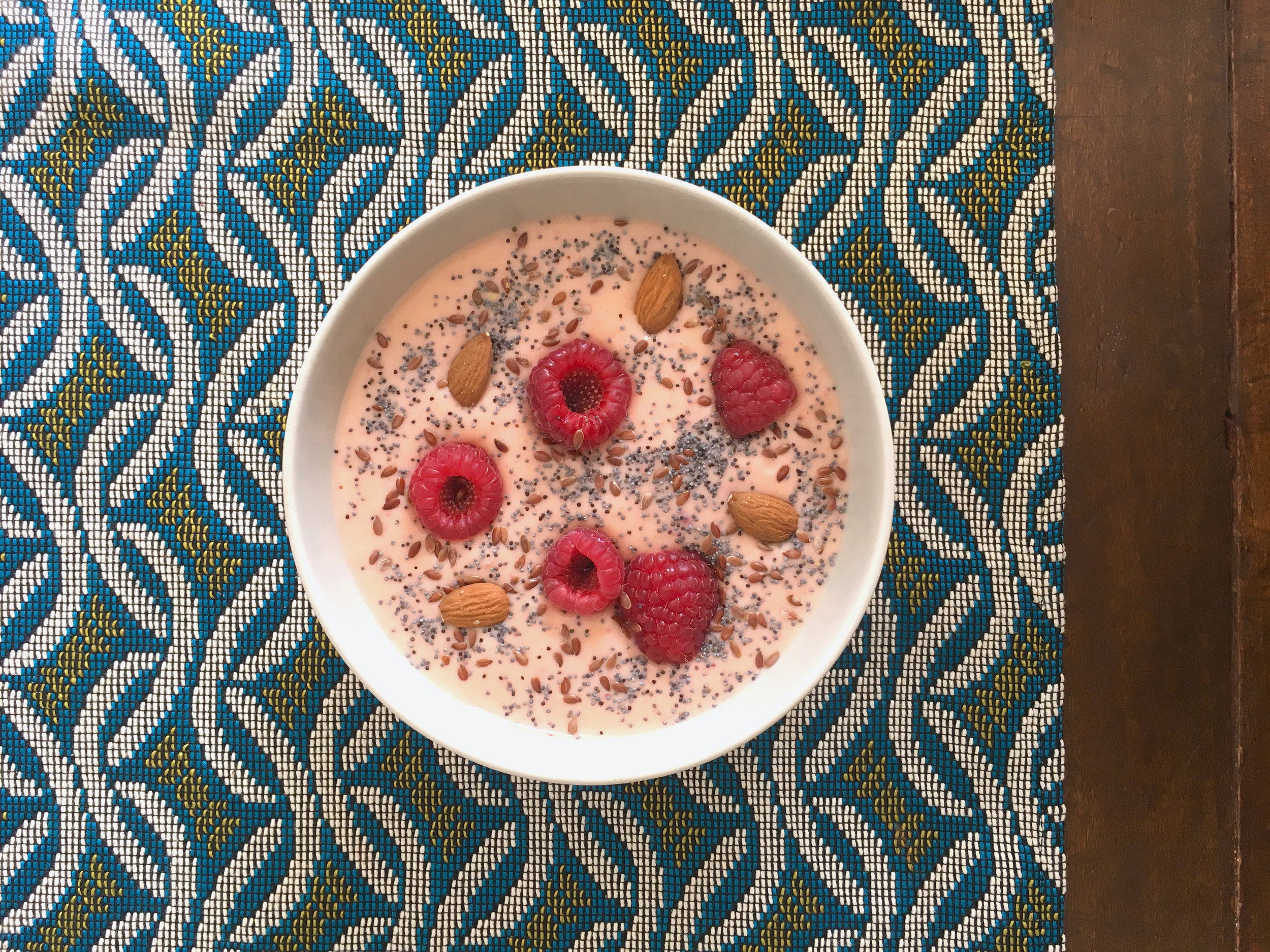 pink smoothie bowl with raspberries and almonds
