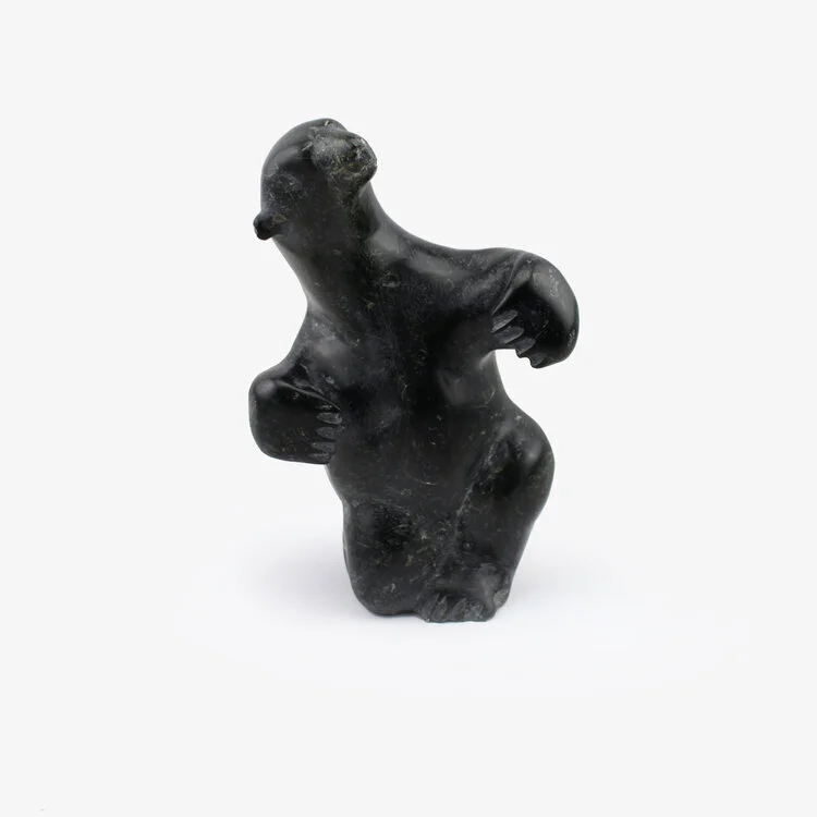 Carved Inuit soapstone figure of a bear kneeling on one knee with head turned and upper limbs held out, late 20th century. Size: 8 ½ h x 5 ⅝ w x 3 ¾ d in