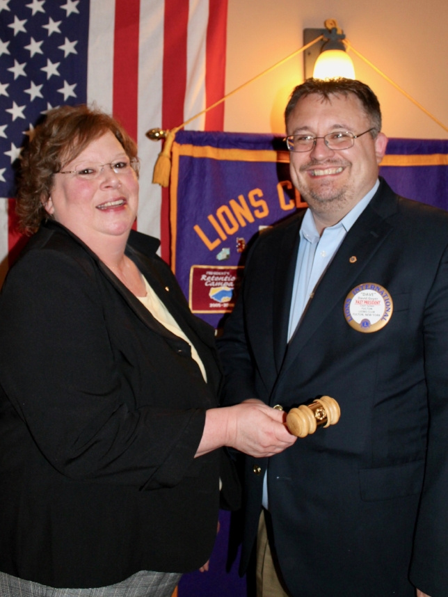 David Guyer, who completed his second term as president of the Fulton Lions Club, hands the club gavel to Michelle Stanard, president for the 2017-18 year. 