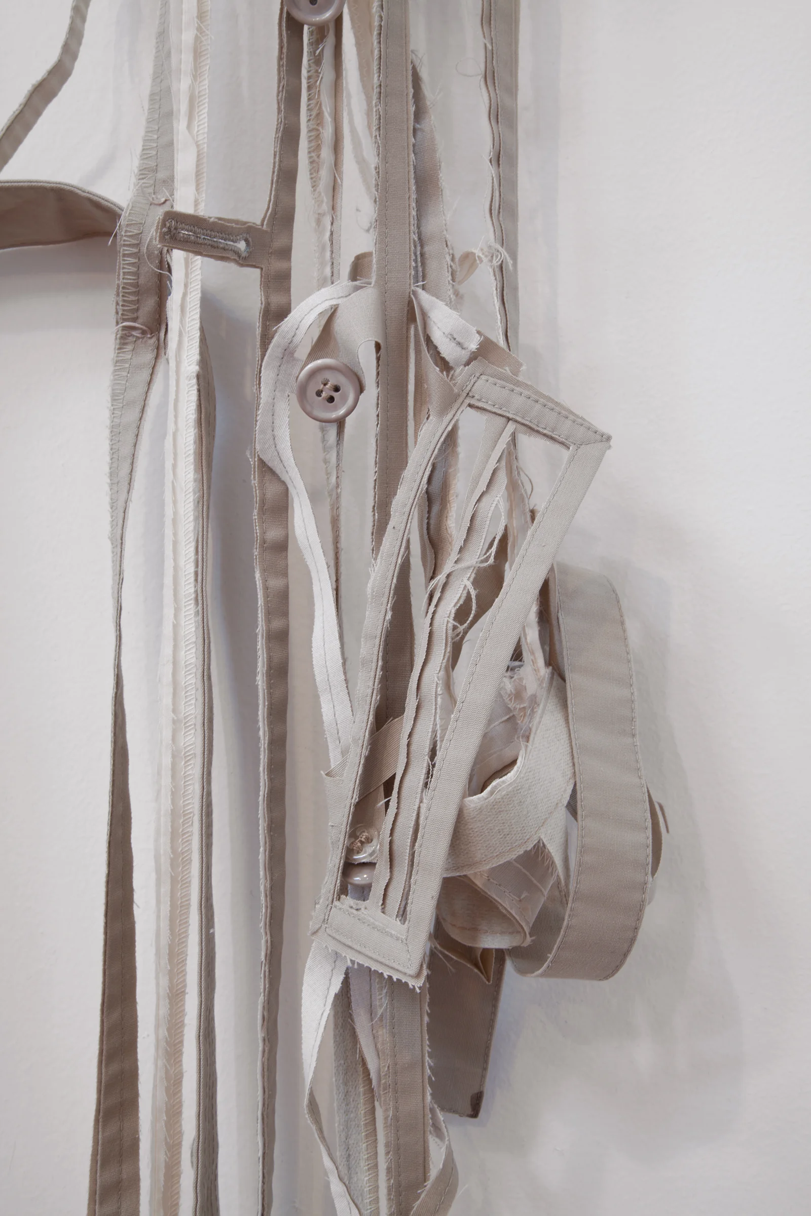 ANNA SEW HOY (detail) beige/cream , fired stoneware, trench coat and resin finger hook, 55" x 17" x 3.5", 2012