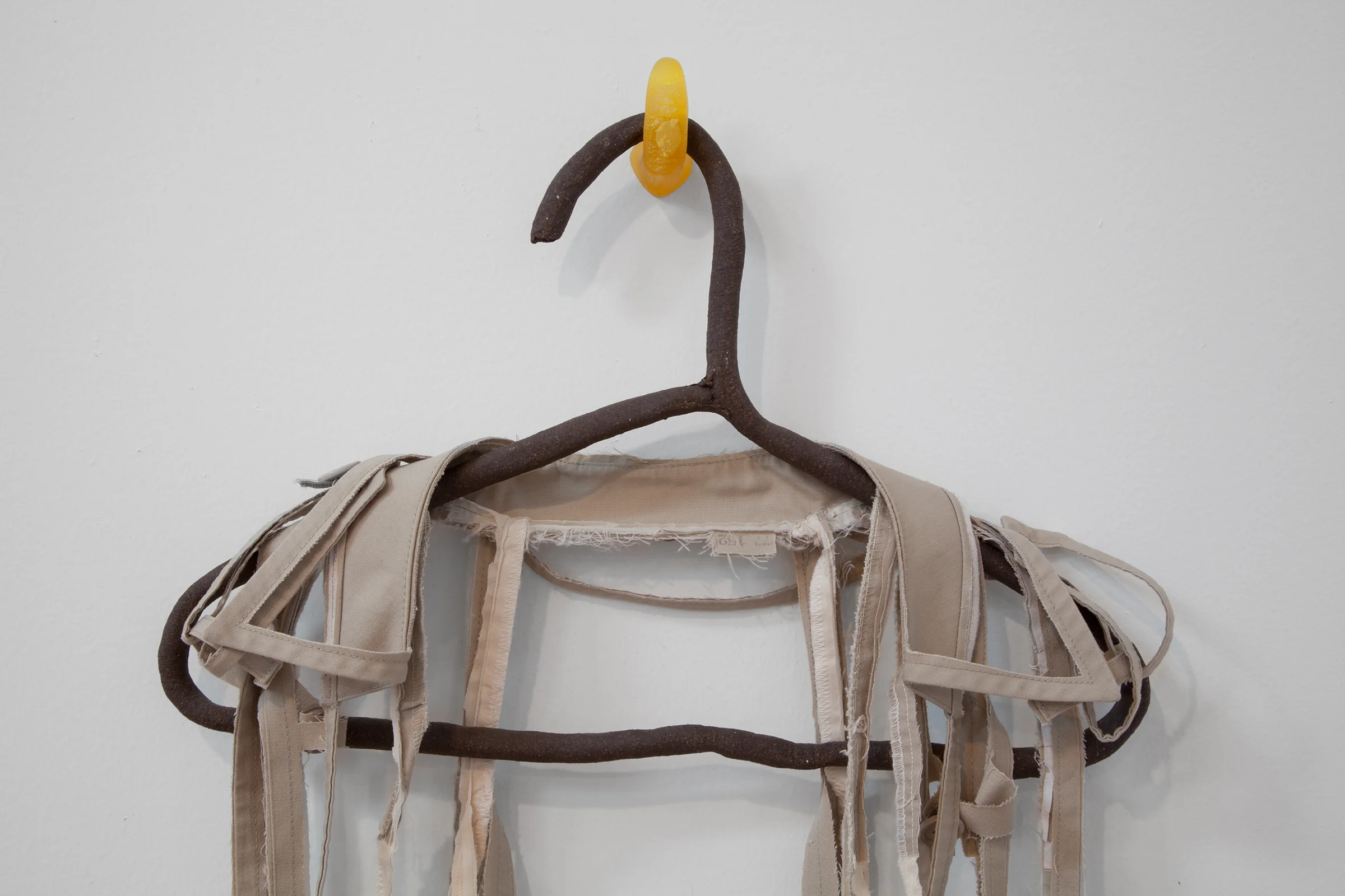 ANNA SEW HOY (detail) beige/cream , fired stoneware, trench coat and resin finger hook, 55" x 17" x 3.5", 2012
