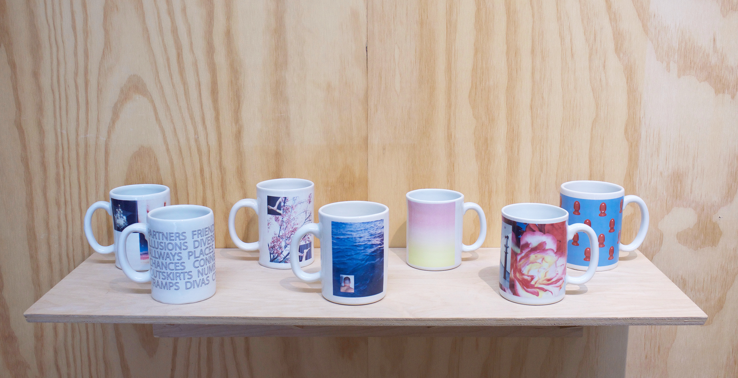  Erik Scollon Shelf #1, 2018 7 individual handmade porcelain mugs with artist made ceramic decals, glaze and wooden shelf, 6” x 32” x 11"  