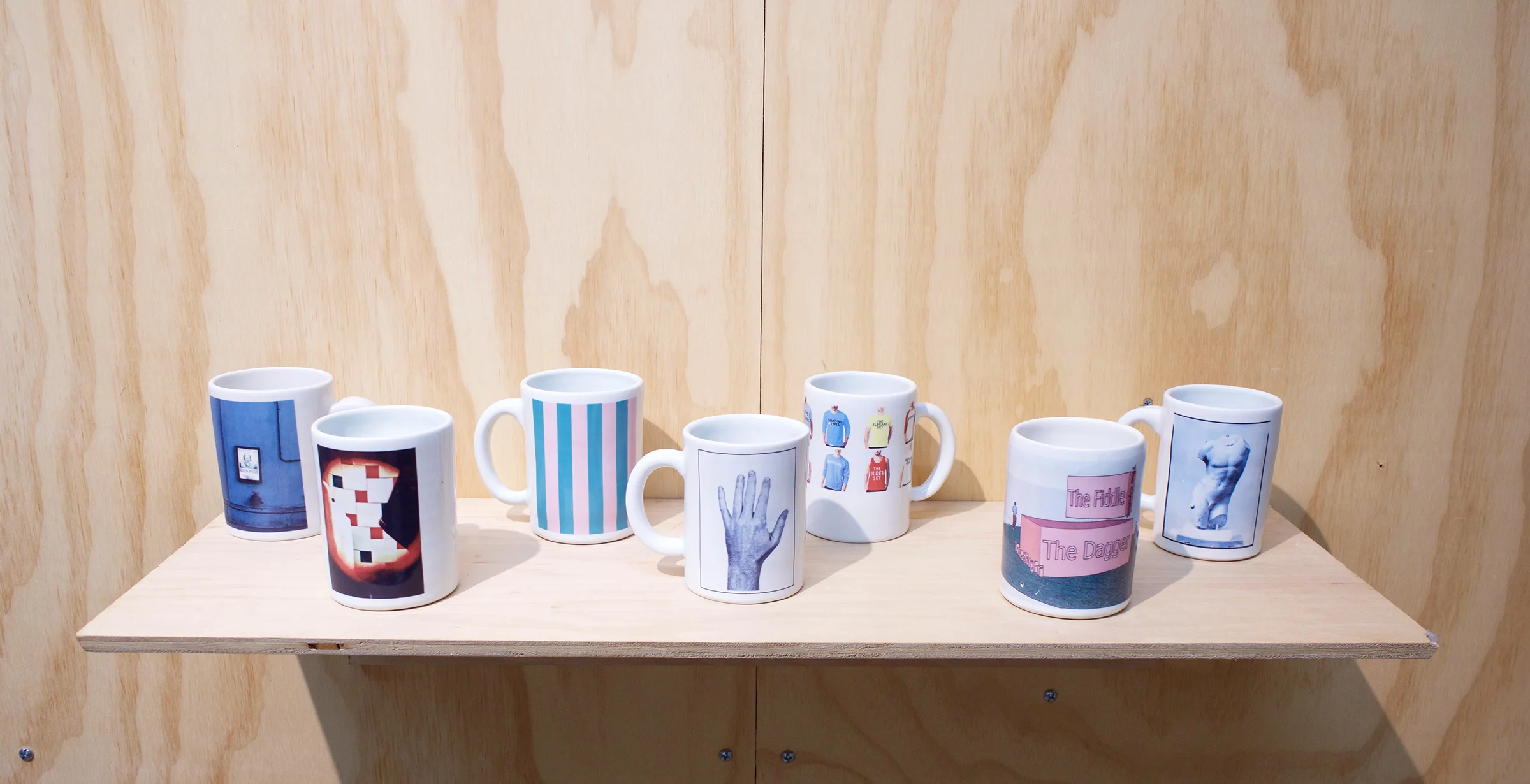 Erik Scollon Shelf #2, 2018 7 individual handmade porcelain mugs with artist made ceramic decals, glaze and wooden shelf, 6” x 32” x 11"