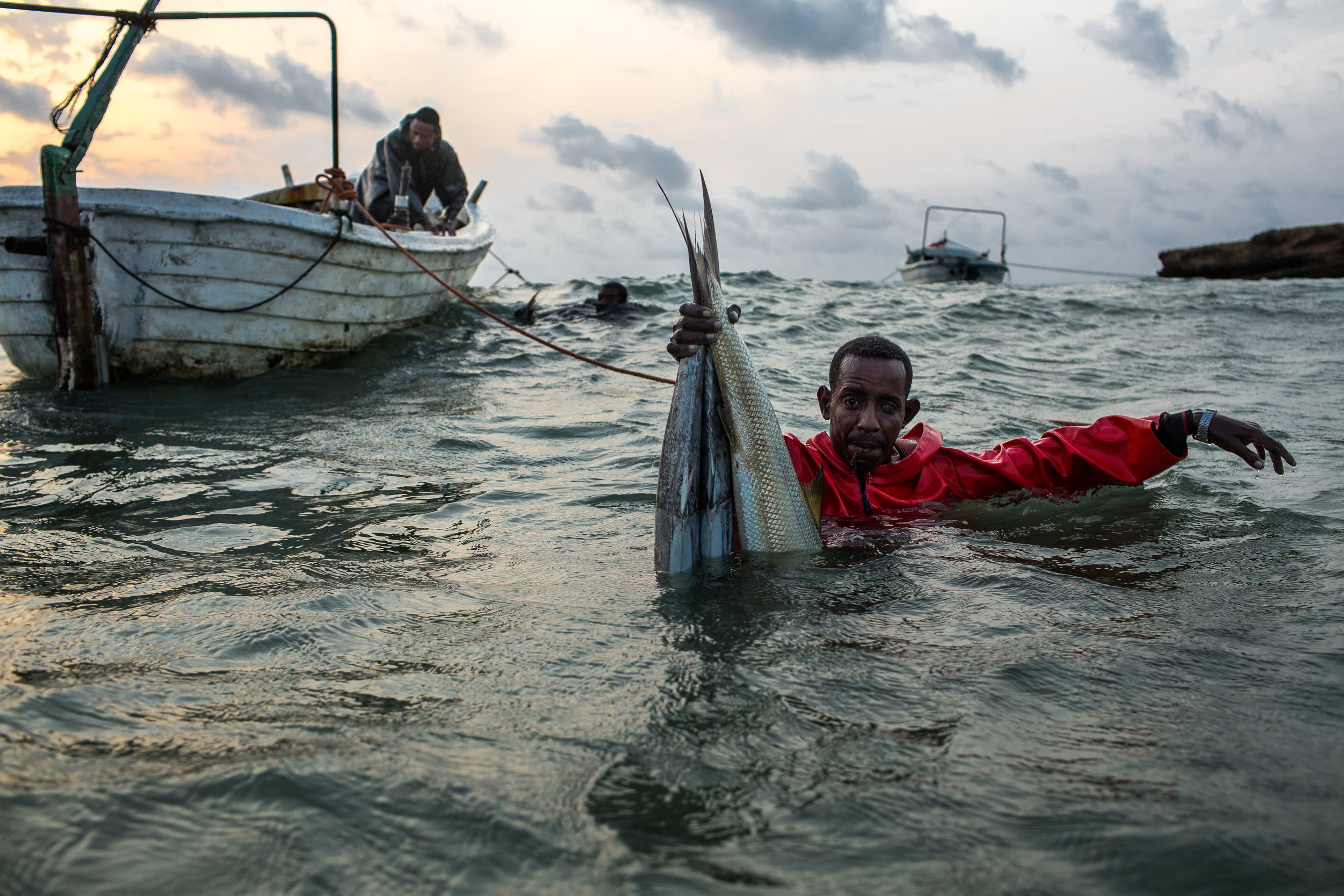  An ocean fisherman brings in the day's catch near a beach in Kismayo, Somalia, July 2017. 