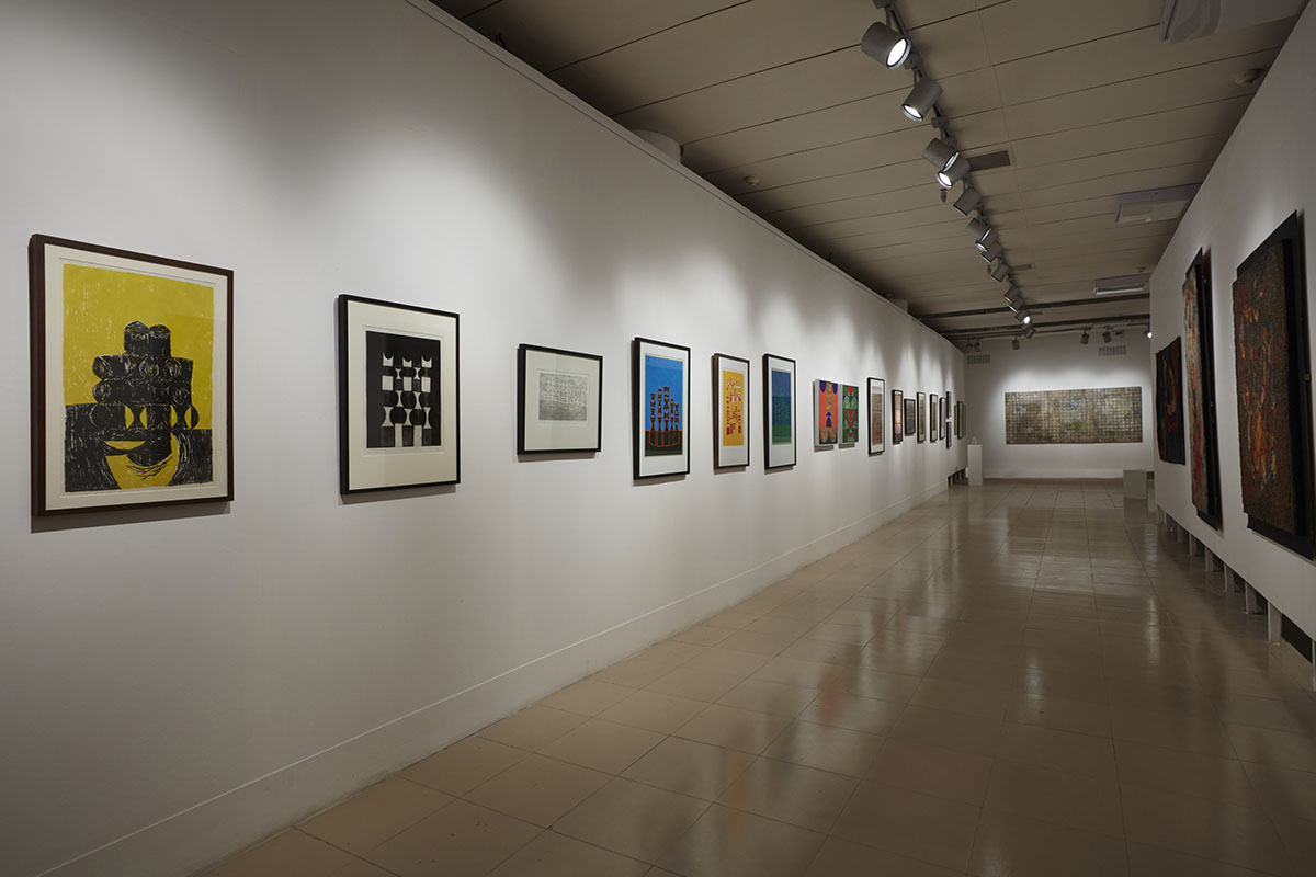 Installation view, works by Anwar Jalal Shemza (left). Courtesy of Jhaveri Contemporary, Mumbai and the Estate of Anwar Jalal Shemza, Eastbourne, UK, Rashid Choudhury (right). Courtesy of the Bangladesh National Museum, Bangladesh Shilpakala Academy, Anwar Hossain Manju Collection, Dhaka and Farooq Sobhan Collection, Dhaka and Zahoor Ul Akhlaq (back), courtesy of the Inayat Ismail Collection, Karachi, the Estate of Zahoor Ul Akhlaq, Lahore and Toronto, Jhaveri Contemporary, Mumbai and the Pakistan High Commission, Dhaka. Photo courtesy of the Dhaka Art Summit and Samdani Art Foundation. Photo credit: Jenni Carter