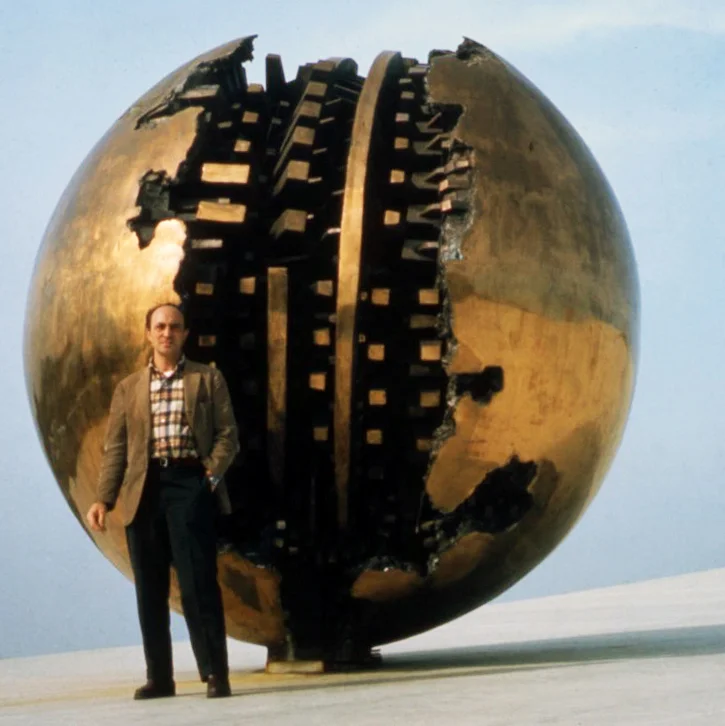 Arnaldo Pomodoro in front of “Sfera grande,” 1966-67 (bronze ø 350 cm) installed on the roof of the Italian Pavilion at the Montreal Expo, 1967. Photograph Ugo Mulas © Eredi Mulas. All rights reserved.