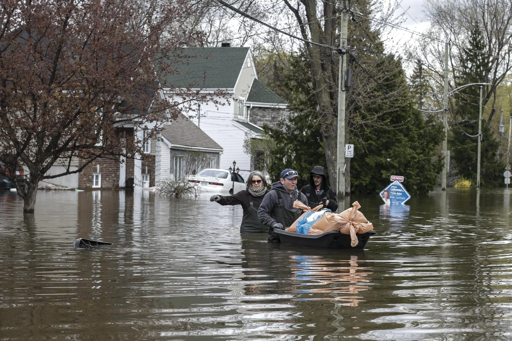  May 09, 2017 - Deux-Montagnes, Quebec, Canada: Resident of Deux-Montagnes leaves their house with some personal effect using plastic bags to protect them. (Normand Blouin/Polaris) 