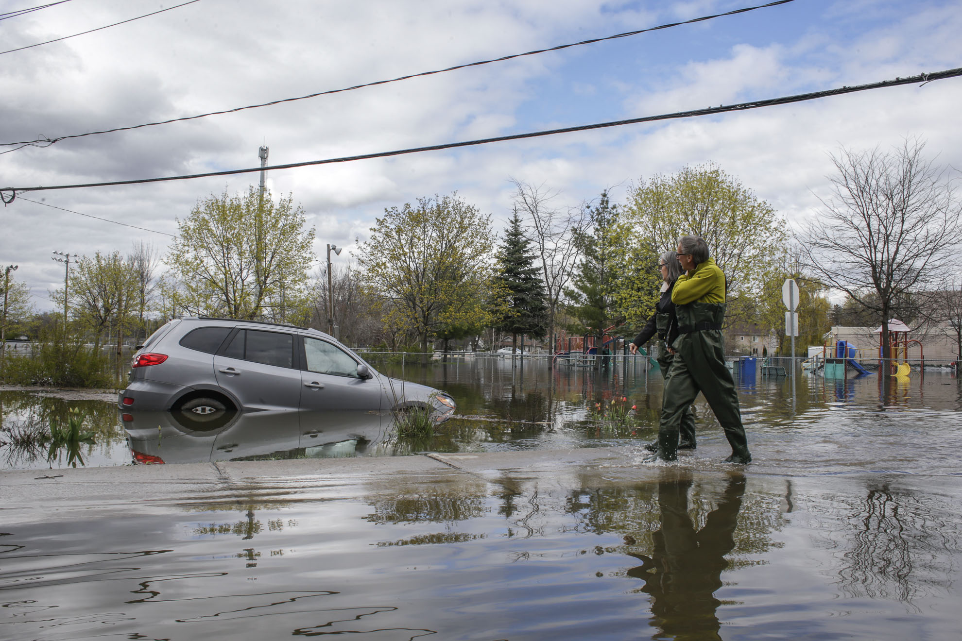  May 09, 2017 - Deux-Montagnes, Quebec, Canada: A couple uses the side walk to avoid deep water. (Normand Blouin/Polaris) 