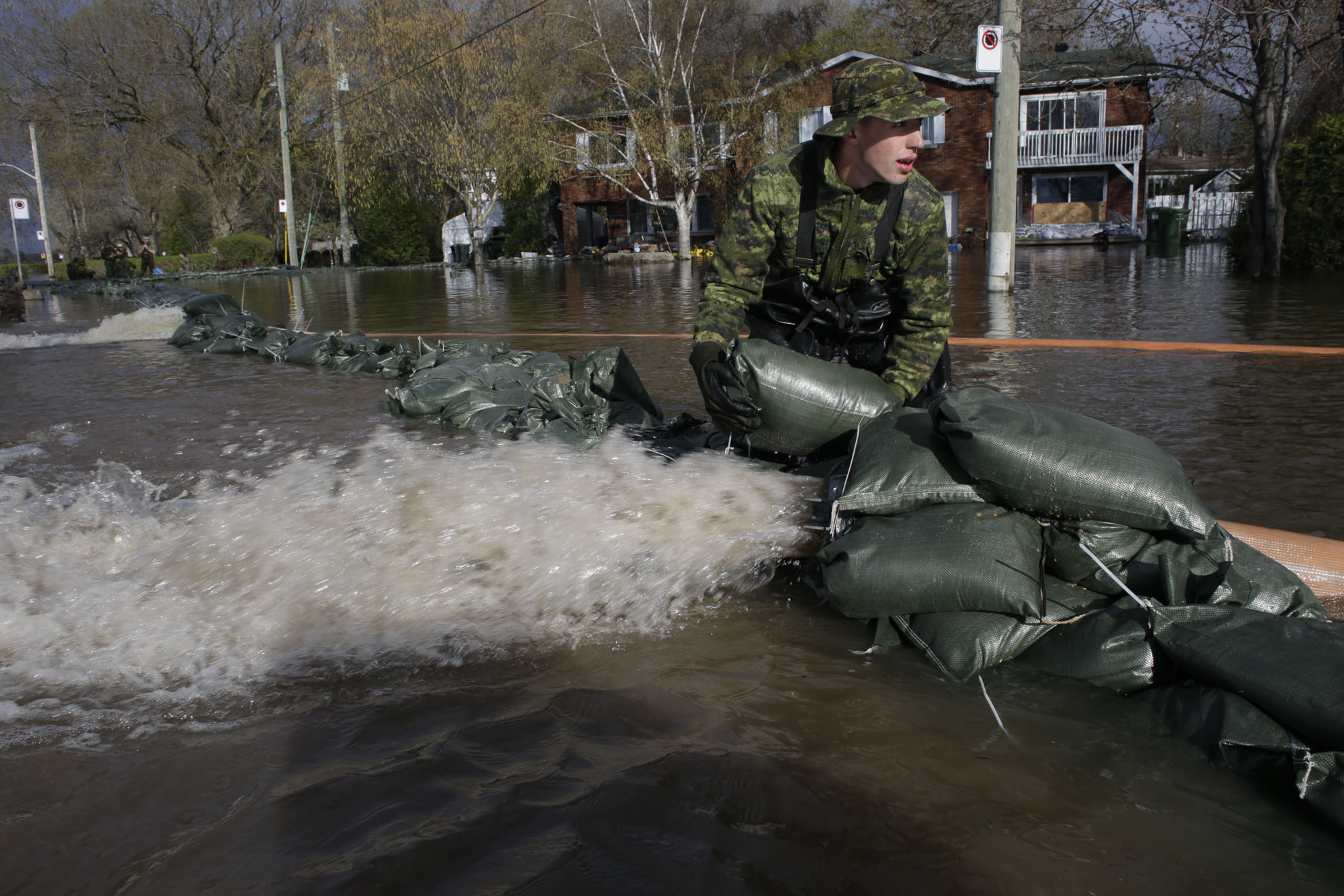  May 09, 2017 - Pierrefond, Quebec, Canada: Private Moisan of the 35th Regiment of combat enginer instals sand bags to secure a 8 inchs pipe. (Normand Blouin/Polaris) 