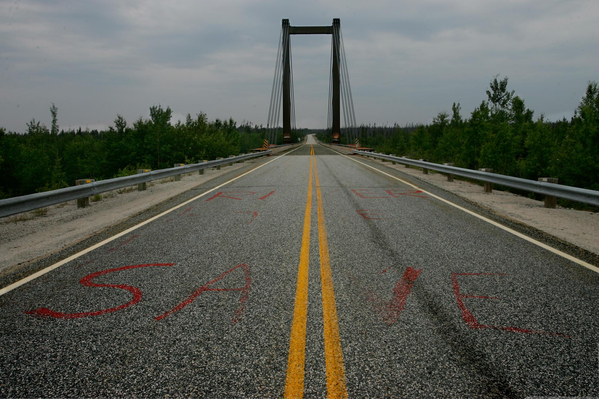  Rivière Rupert, Juillet 2006. Le pont qui enjambe la Rivière Rupert  sur la route de la Baie James au rapide Oatmeal est couvert de message messages sans équivoque. Ici sur le bitume on a peint en lettres rouges, Save The River 