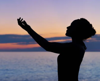Woman raising hands to the sky sunset