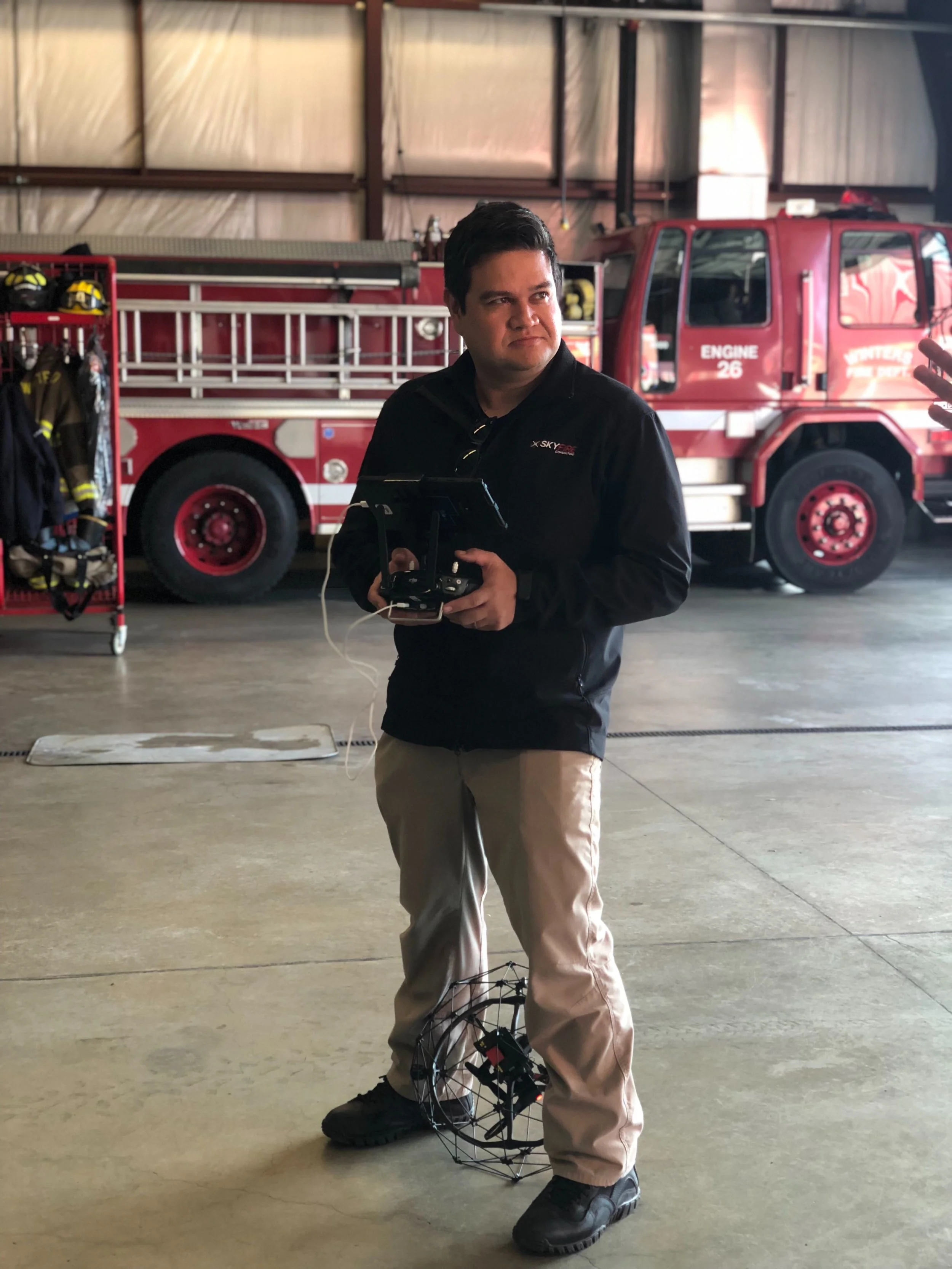 Walt pretending to fly a drone in a firehouse.jpg