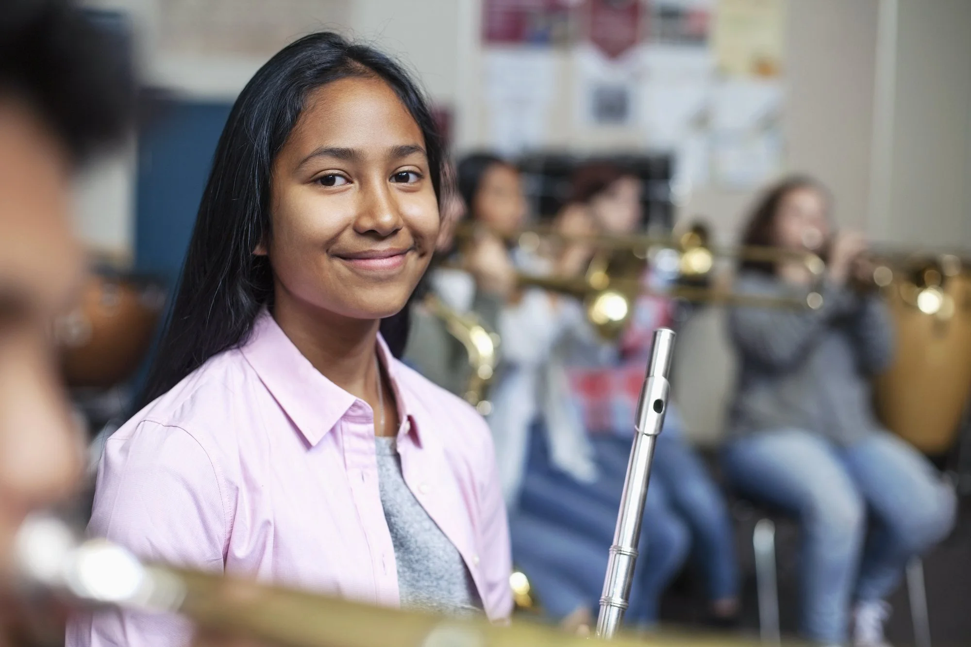 Teenage student playing flute in a school orchestra rehearsal