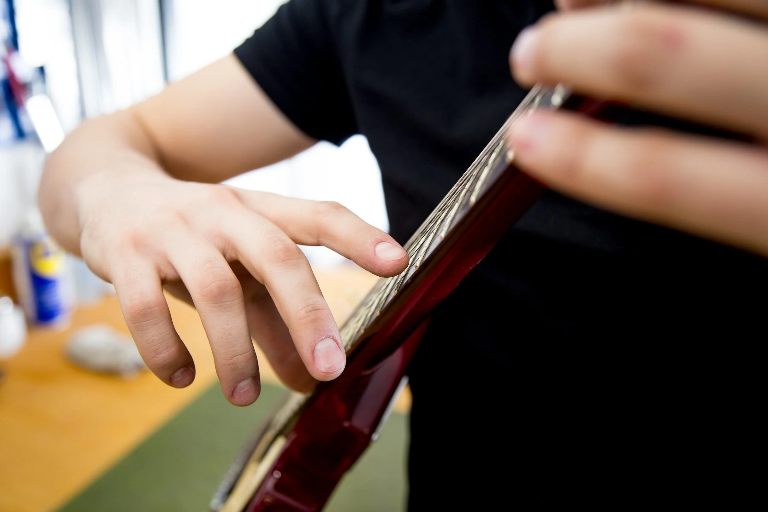 Guitar being tuned at the Collingswood Music repair bench by an experienced repair technician