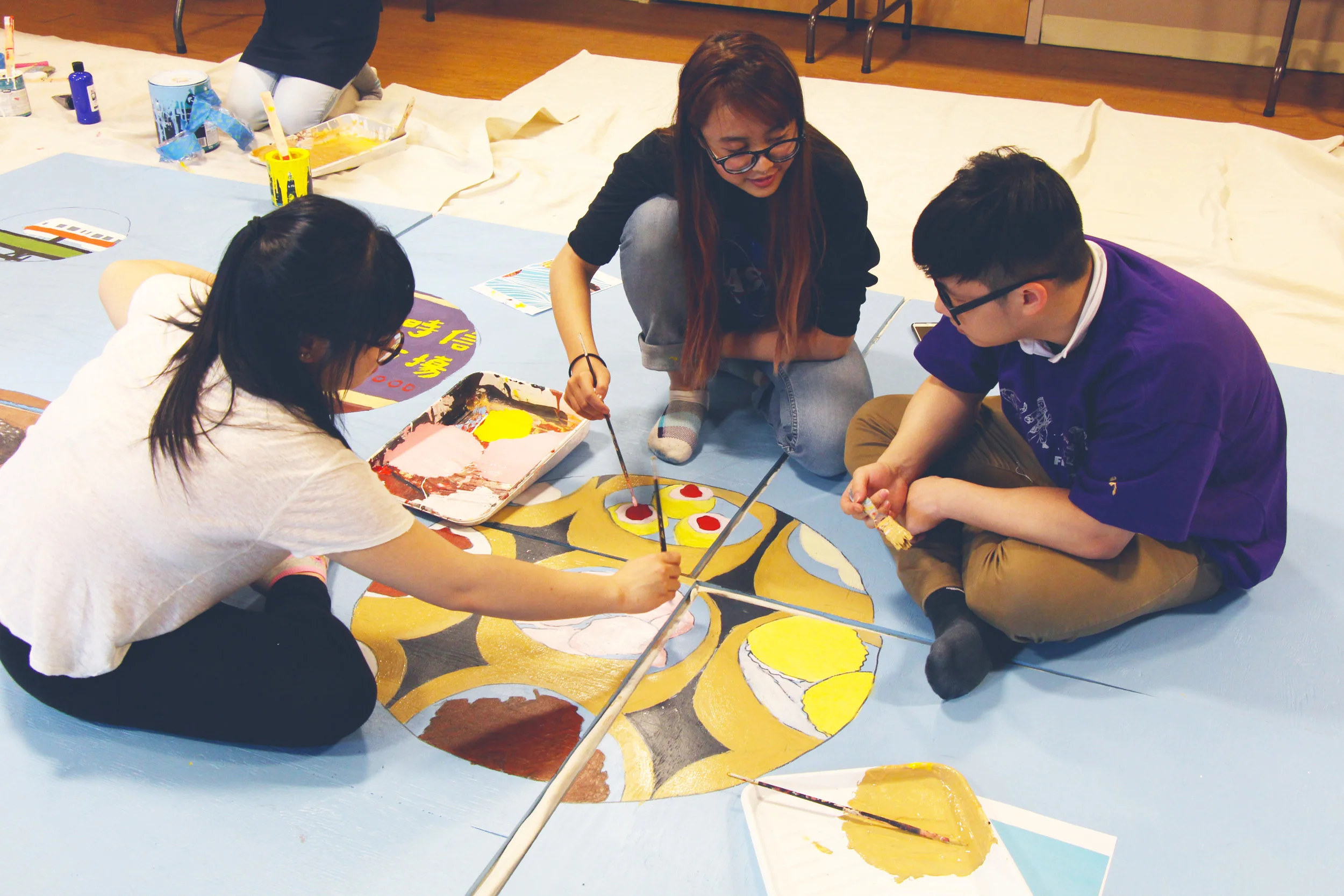 Youth artists painting the 2017 ThinkChinatown Project, a mural currently on display on the facade of 15-25 Harrison Avenue.