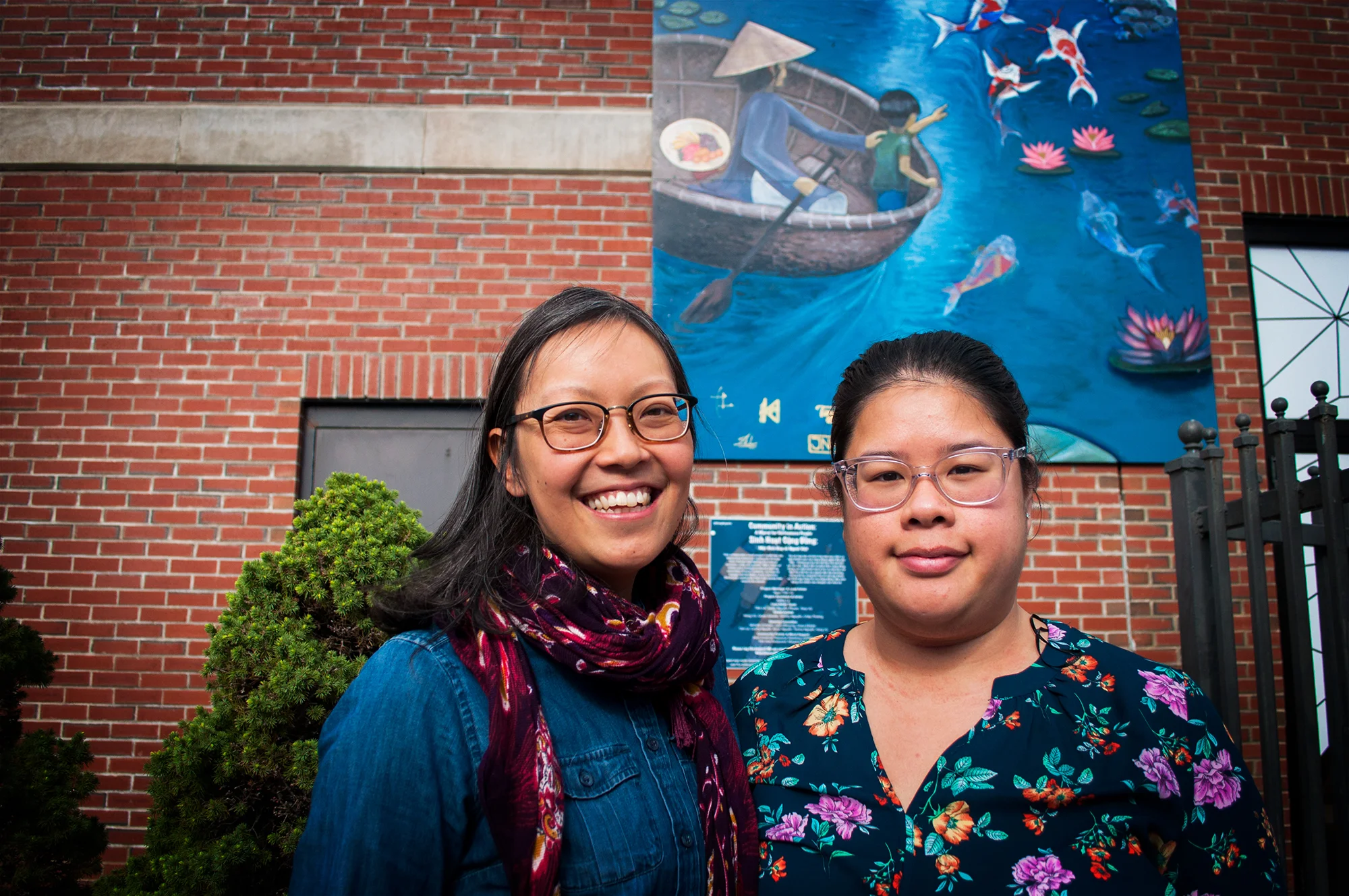 Amy (left) pictured with Carro, a former A-VOYCE youth from 10 years ago, in front of the new community mural in Dorchester's Fields Corner.