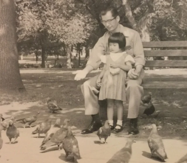 Cynthia with her Uncle Eddie, who is teaching her how to feed pigeons in the Boston Common.&nbsp;Photo Courtesy of Cynthia Yee.