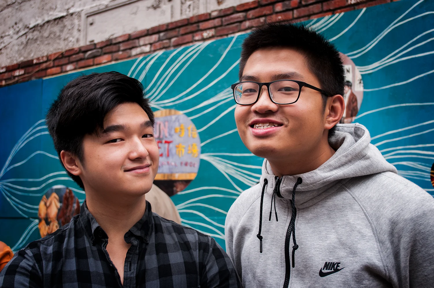 Photo: A-VOYCE Alumni Zi and Billy in front of the ThinkChinatown Mural “Tied by a Thousand Threads” during the unveiling event