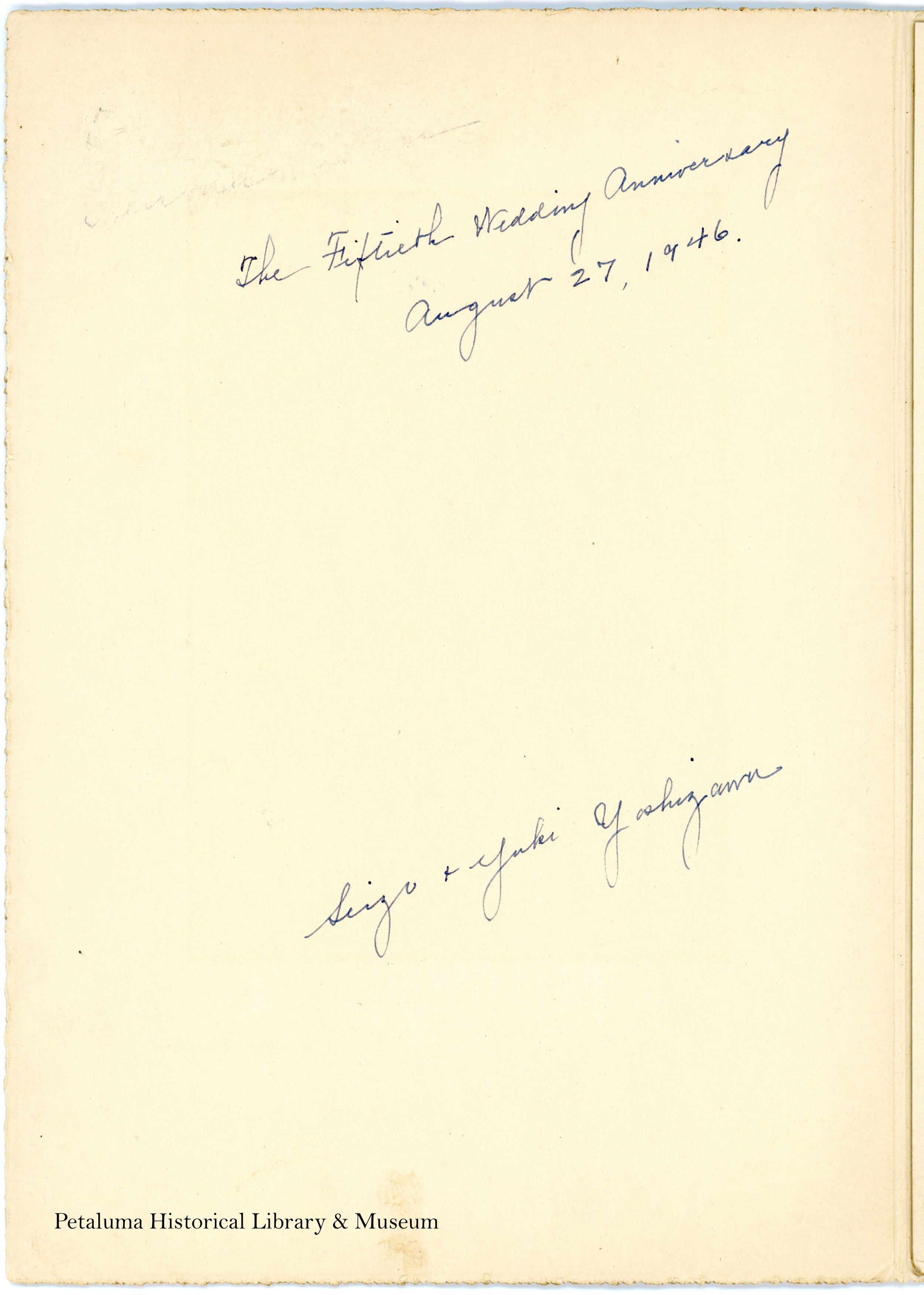 The cream colored back side of a photograph with writing on it.