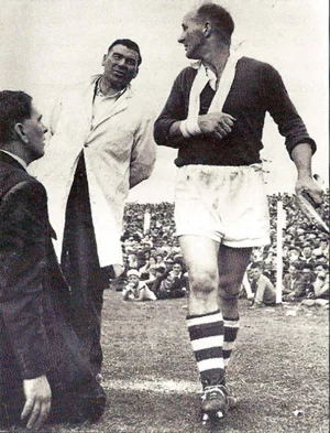 30th June 1957. The Munster semi-final between Cork and Tipperary at Limerick which Cork won by 5-2 to1-11. In the second half Christy Ring went off with a broken wrist. Mick Mackey. who was doing umpire for referee Mick Hayes of Clare, says something to Christy Ring as he leaves the field.