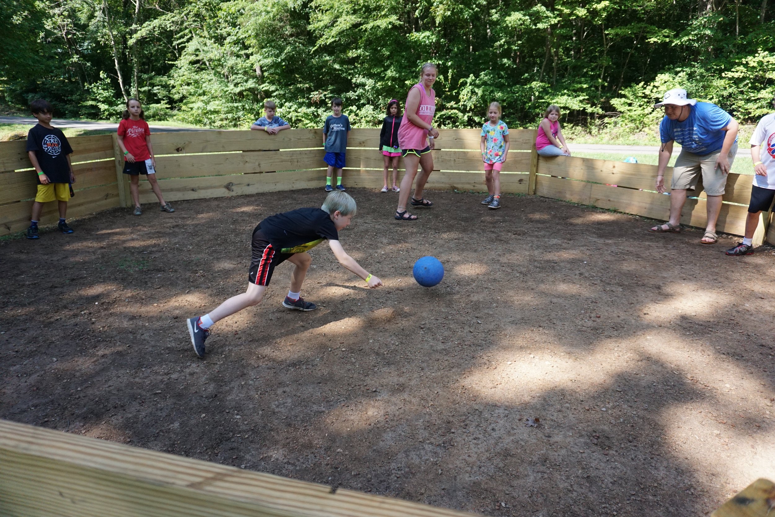 An intergenerational group of Summer Campers playing ball in a circle - NaCoMe Camp &amp; Conference Center 