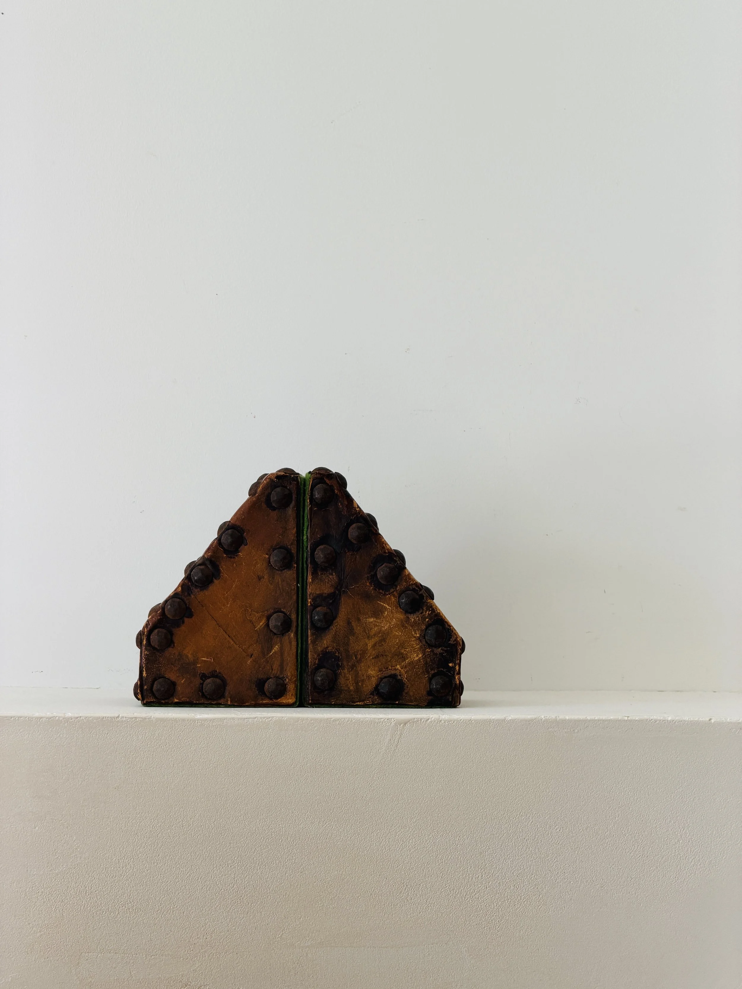 MATERI(A)NTIQUES SET OF WEATHERED COGNAC LEATHER STUDDED AND FELT LINED TRAPAZOIDAL BOOKENDS(8).jpg