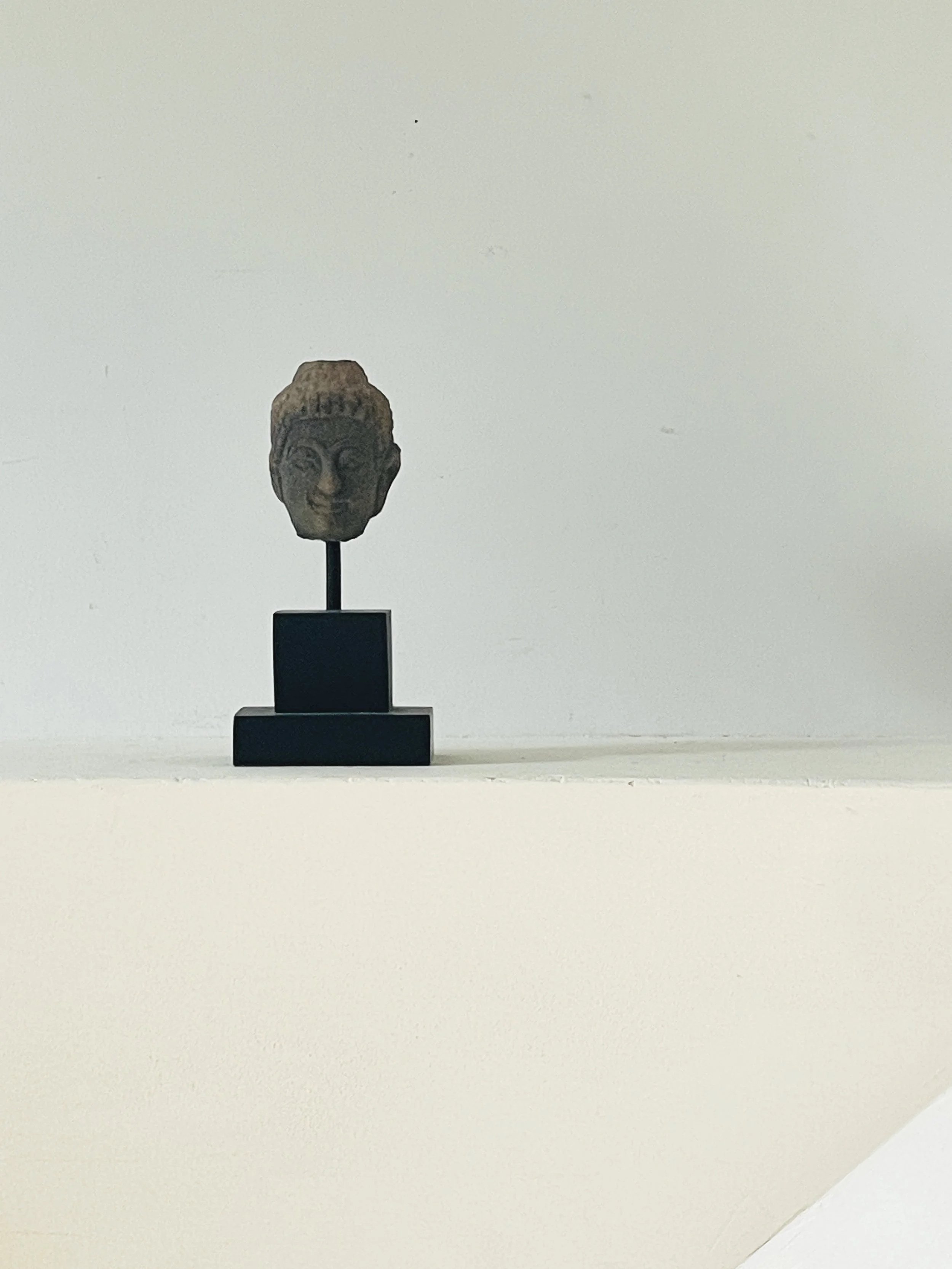 MATERI(A)NTIQUES SMALL CERAMIC BUDDHA HEAD ON BLACK STAND