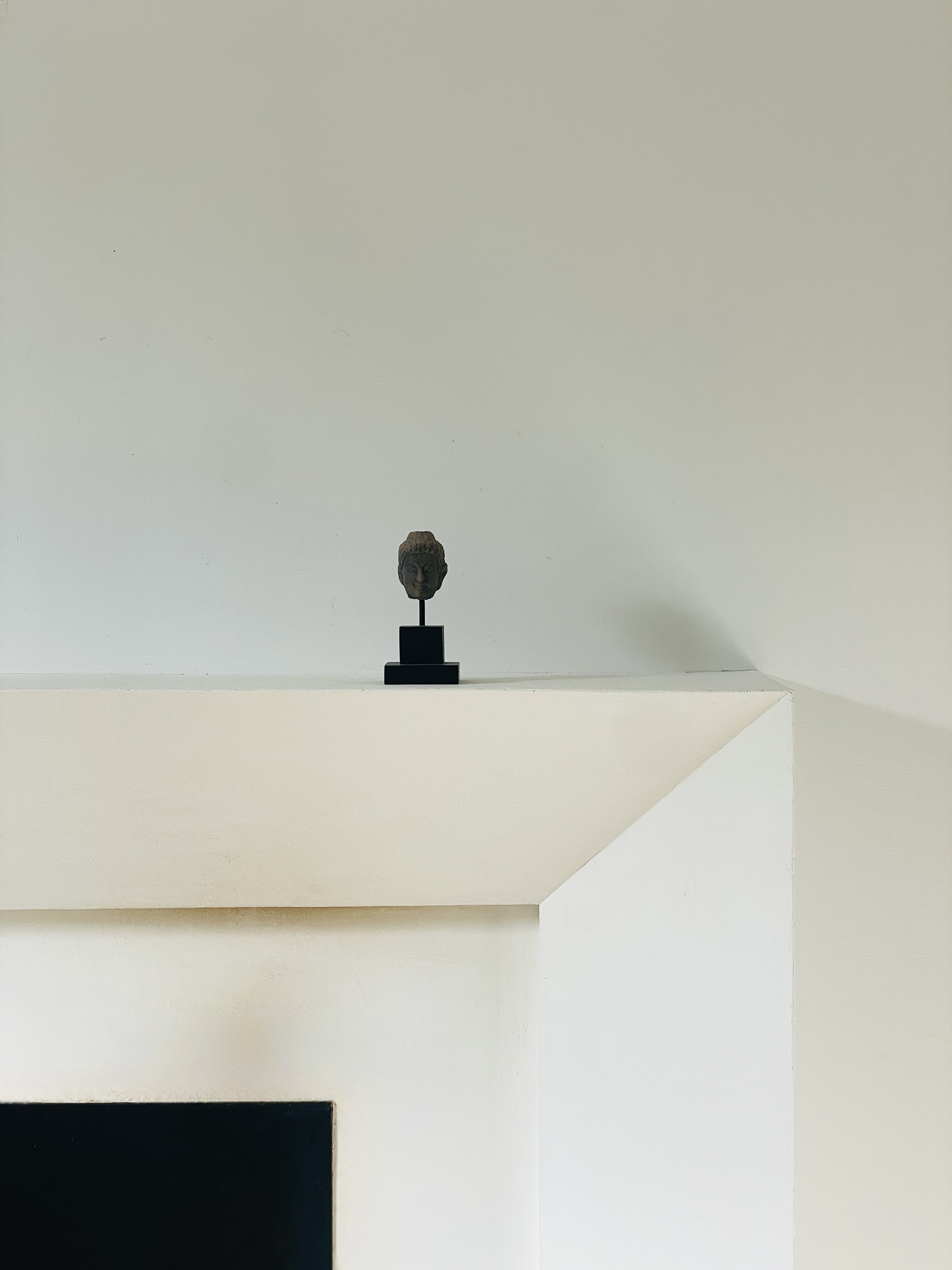 MATERI(A)NTIQUES SMALL CERAMIC BUDDHA HEAD ON BLACK STAND.jpg