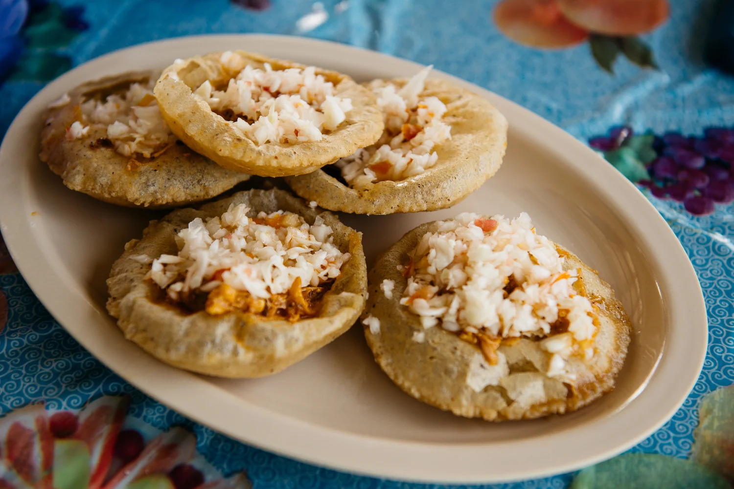 Salbutes: A corn tortilla that puffs when fried, then popped open and filled with recado-spiced meat, cabbage, and cheese
