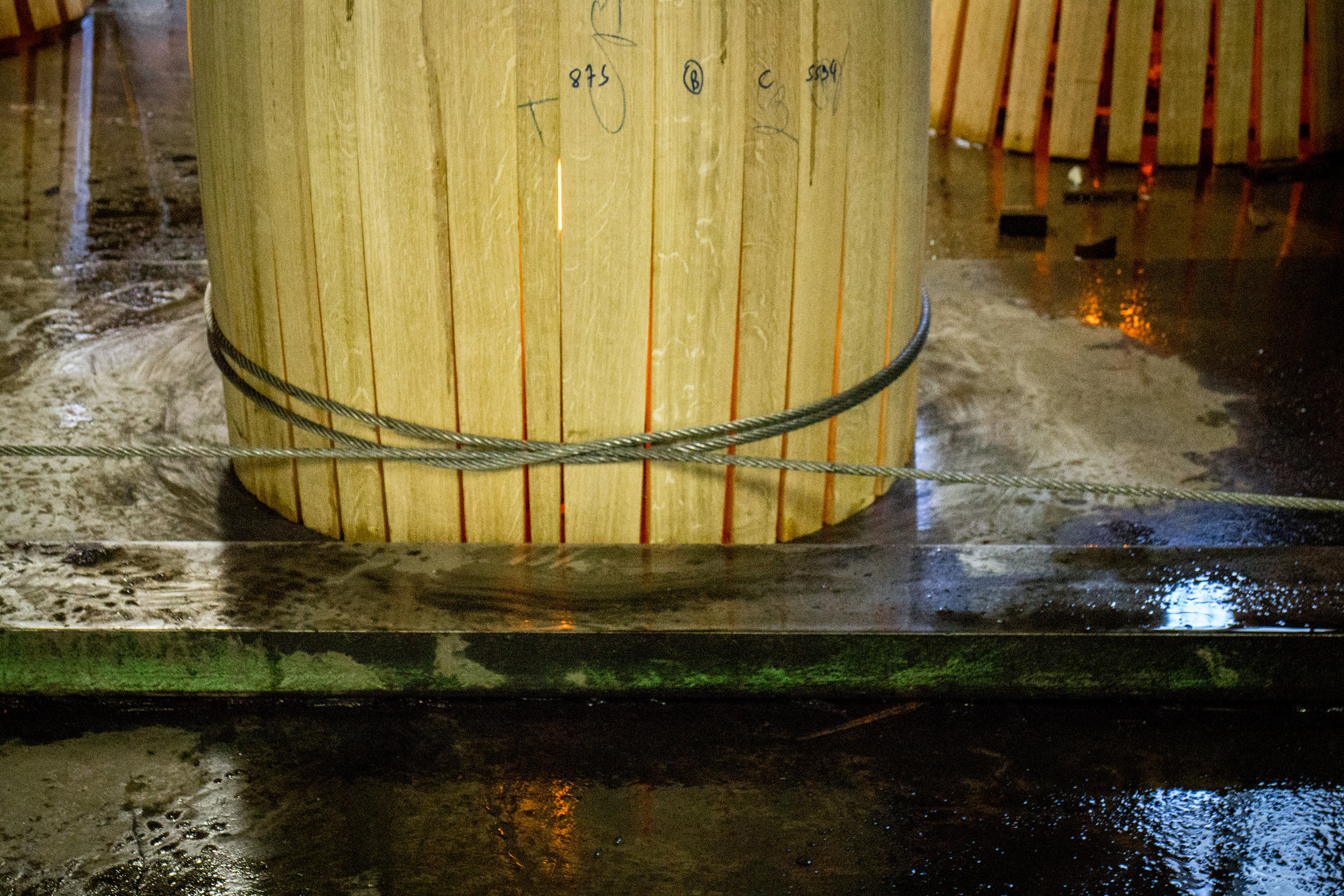 Machine & cord gradually bending the barrel staves into shape.