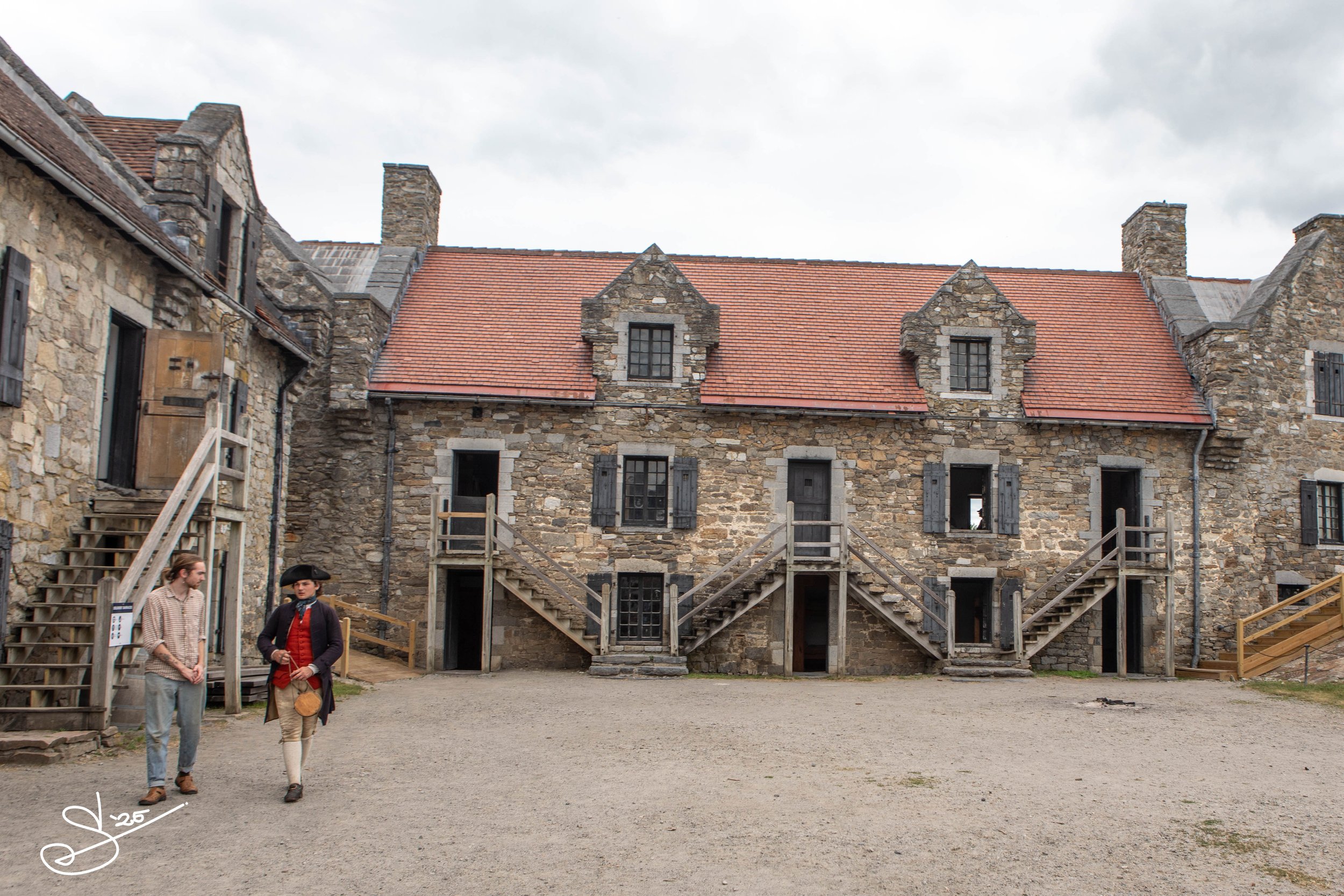 A historical interpreter walks with a fort visitor