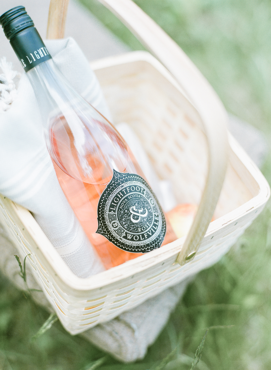 Jacqueline Anne Photography Captured on Film, A cream sunhat on a sunny bench, with a bottle of Lightfoot and Wolfville Wine