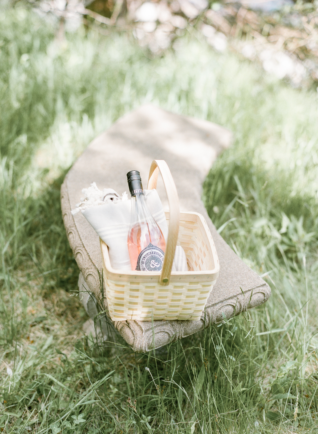 Jacqueline Anne Photography Captured on Film, A cream sunhat on a sunny bench, with a bottle of Lightfoot and Wolfville Wine