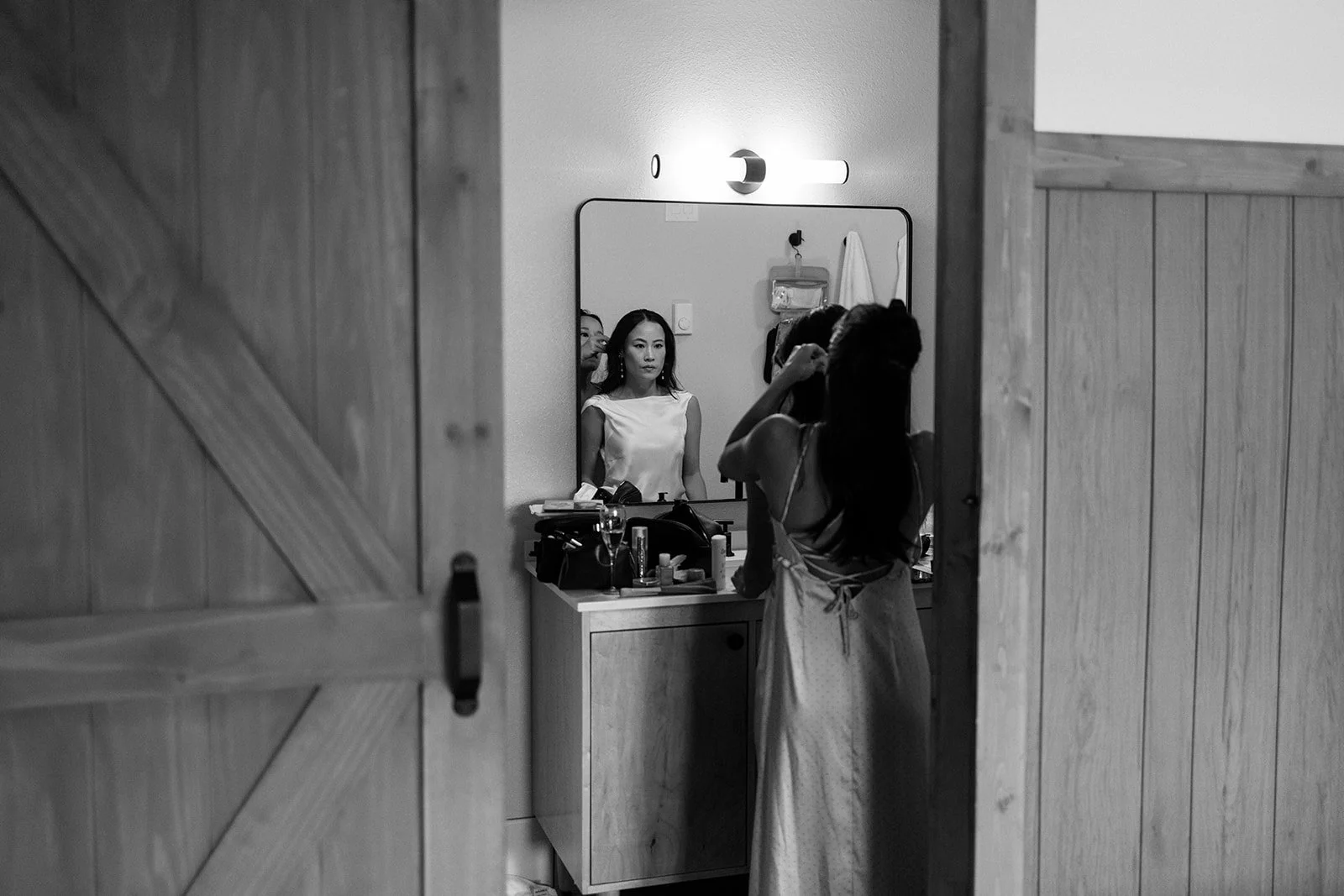 bride getting ready in hotel room with her sisters in Jackson for wedding in grand tetons national park