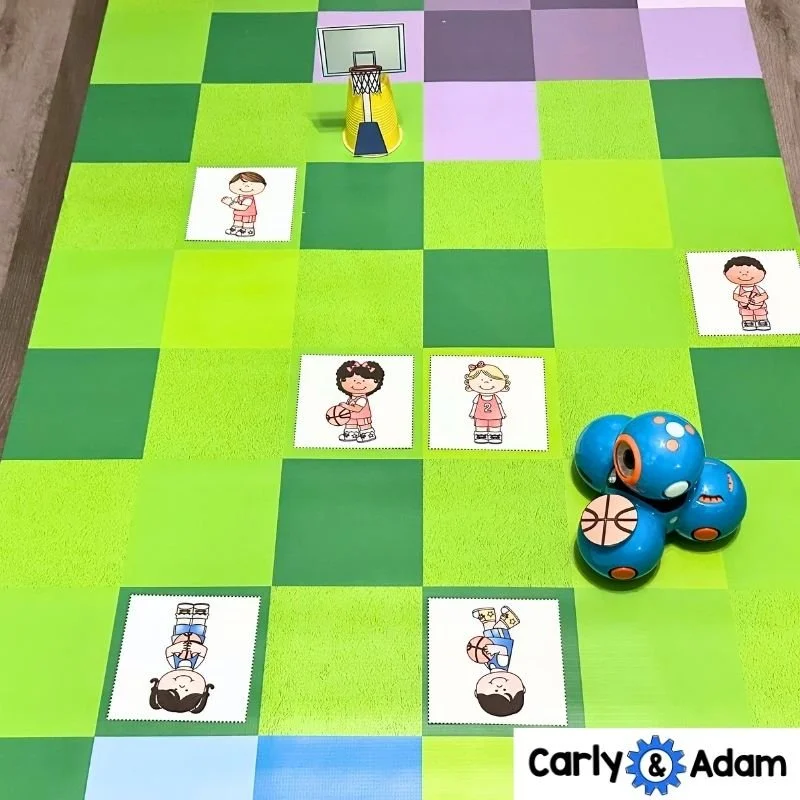 Elementary basketball coding challenge materials including movement cards, coding robot, scoreboard, and printable hoop for STEM class.