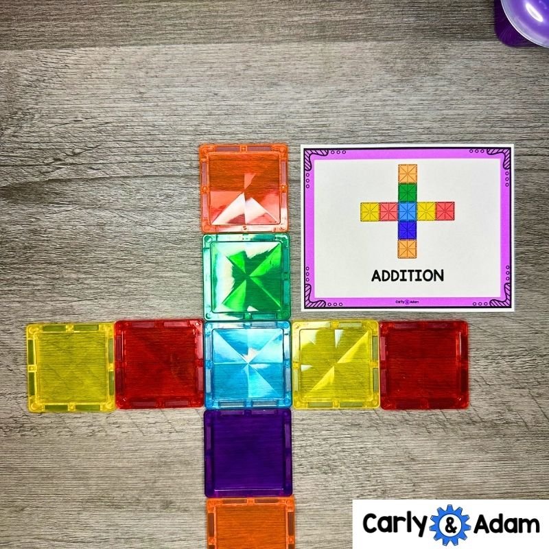 Colorful square magnetic tiles form a plus sign beside a purple-bordered task card labeled ADDITION.