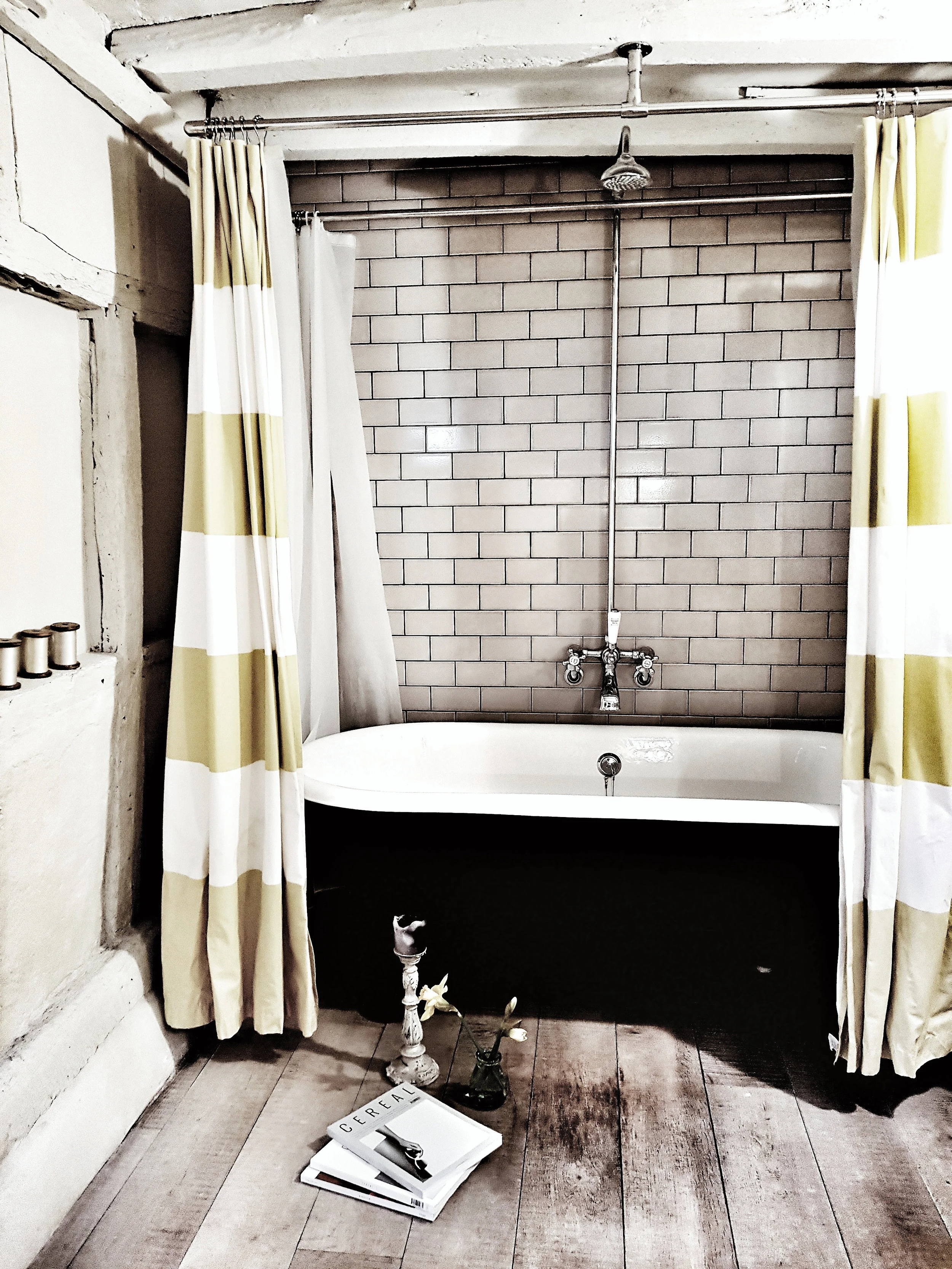 Pale pink metro tiles add a contemporary twist in the bathroom and provide contrast to the timber walls and wooden floors