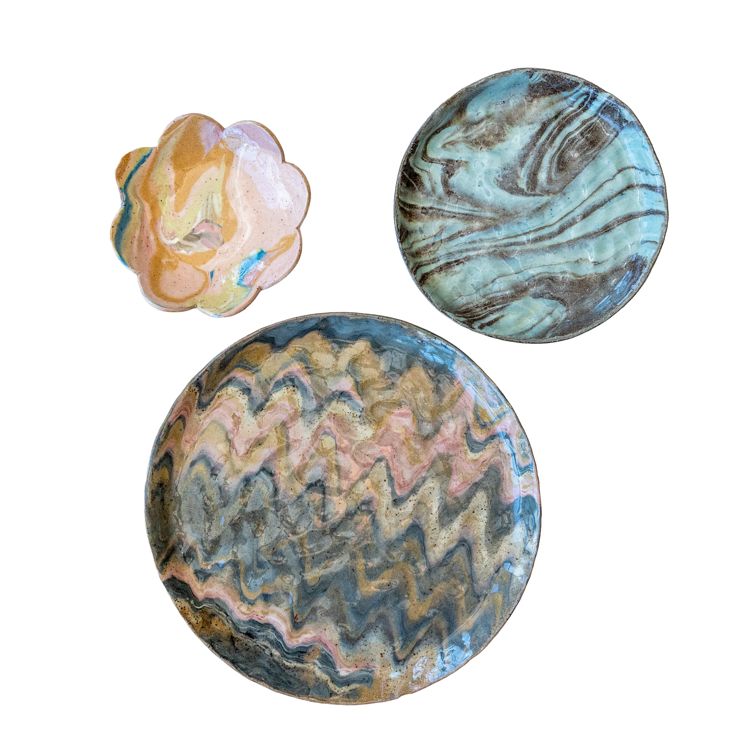 Marbled, colorful stone disks with swirling patterns of blue, gray, pink, and beige on a black background.