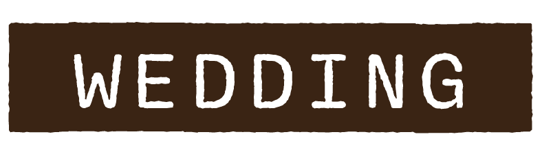A brown sign with black text reading 'WEDDING'.