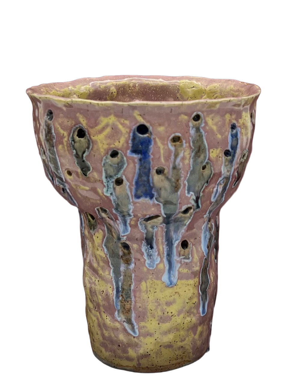 A ceramic vase with a textured surface and multicolored glaze, featuring drip patterns in shades of blue, green, and brown, set against a black background.