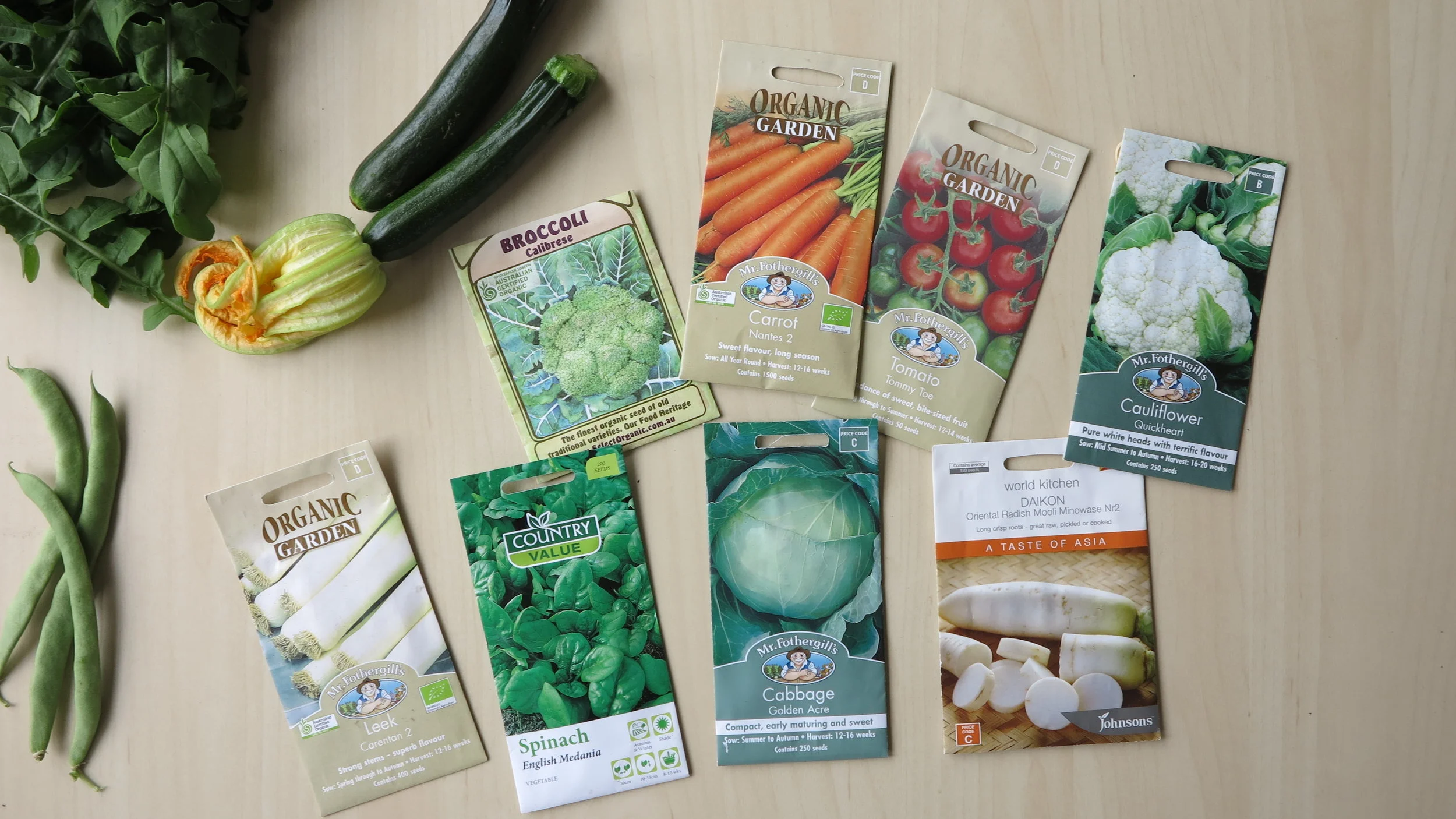 My recent garden harvest to the left (beans, rocket & zucchinis) and my latest seed haul ready for planting in the new patch!