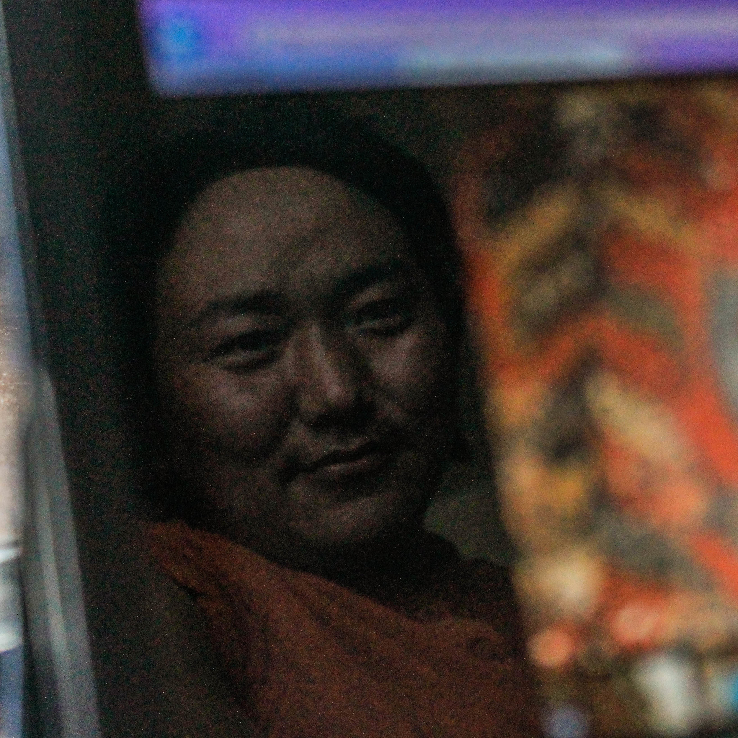  Jigme looks fondly at old photos of his art conservation work in Mustang.&nbsp; 