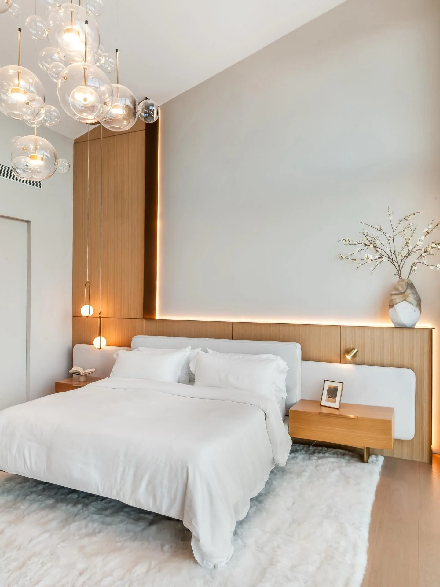 Shores Residence | Primary Bedroom

The dramatic arched ceiling and expansive windows set the stage, contrasted by an airy, light-filled palette. Warm woods, statement lighting, and subtle accent illumination bring warmth and dimension, creating a sp