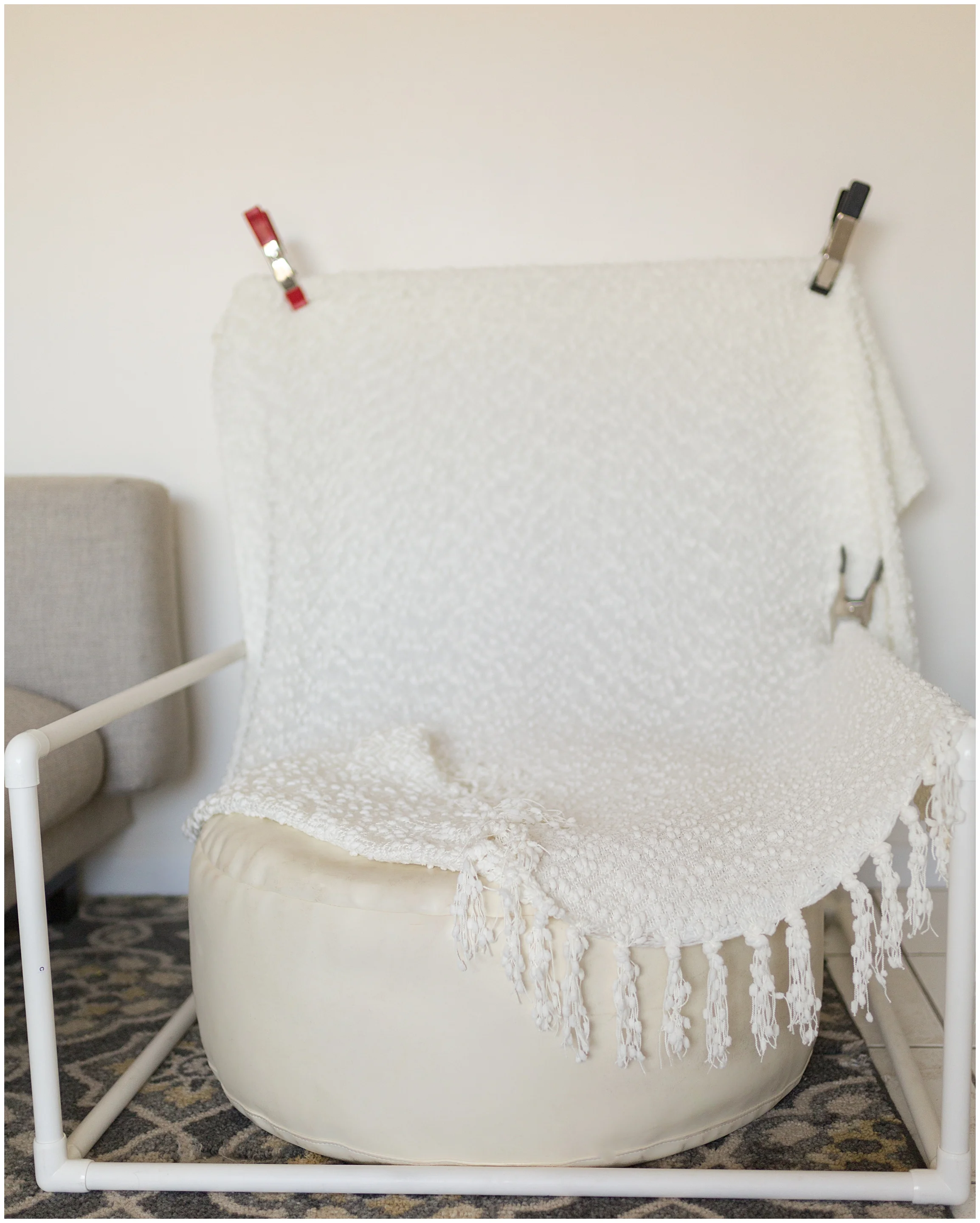 Speaking of bean bag! This is my posing station. I bring this bean bag along with the backdrop stand and build it right in your living room. It only takes a couple minutes and I usually employ a super cute older sibling to “help” assemble it. They l…