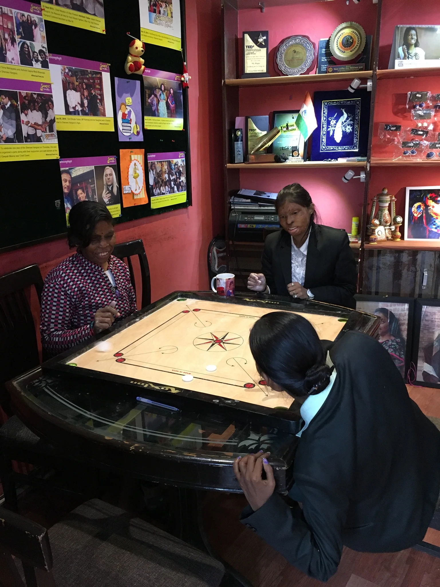  The women intensely focused on their game of carrom 