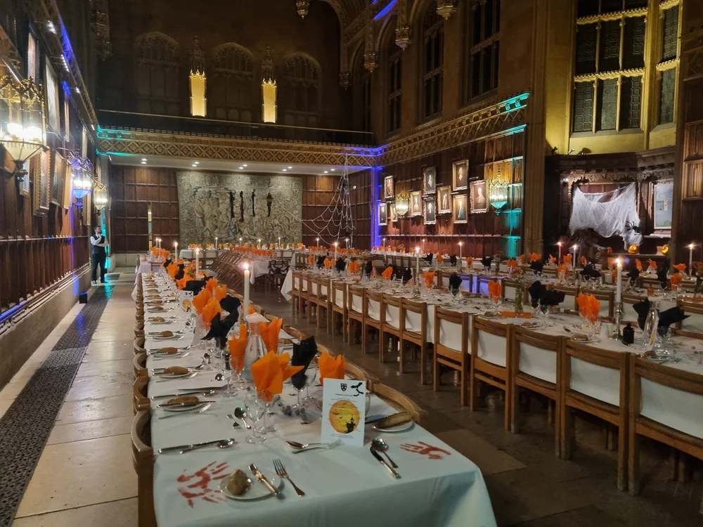 Matthew Garrett performing table magic for guests seated at a long dinner table