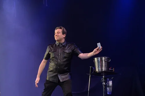 Matthew Garrett performing a live stage magic show for an audience