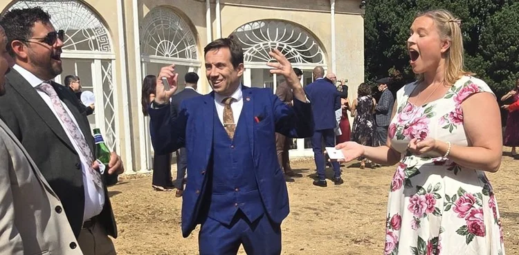 Wedding guests reacting to Matthew Garrett's close-up magic at Barton Hall in Kettering