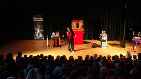 Matthew Garrett performing live stage magic for a large family audience